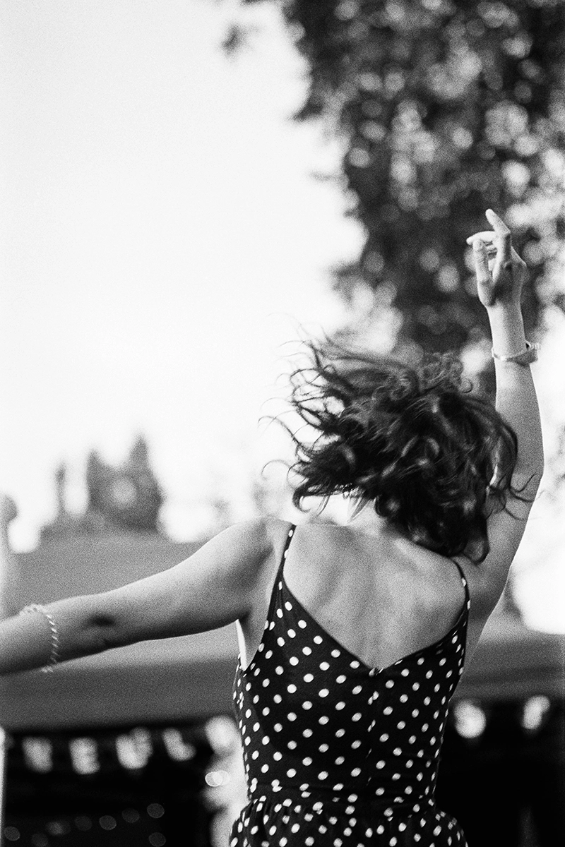 Black and white anlaog photograph of a woman eating a chocolate bar