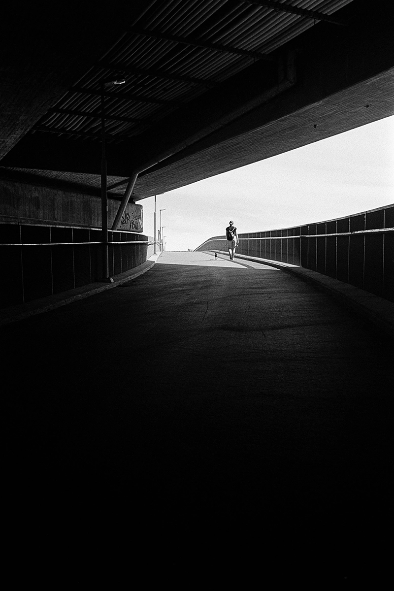 Black and white anlaog photograph of a woman eating a chocolate bar