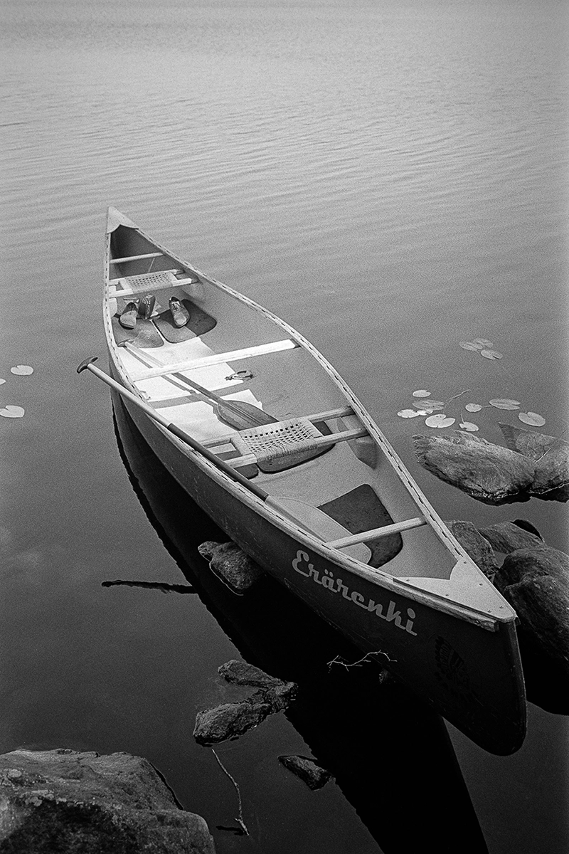 Black and white anlaog photograph of a woman eating a chocolate bar